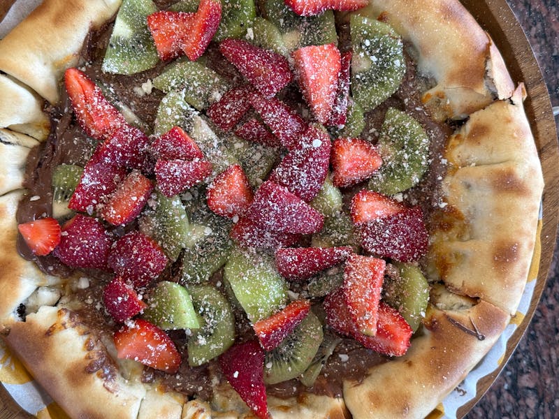 Nutella pizza dessert with strawberries and powdered sugar